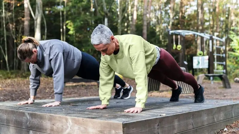 Older adults getting into a plank position to strengthen their core.