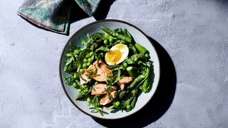 salad bowl with salmon, egg, peas, and asparagus