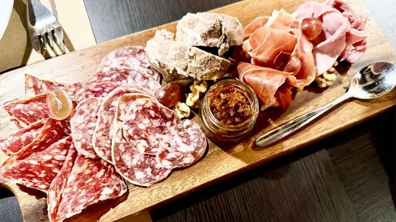 Sliced cold cuts on a wooden platter.