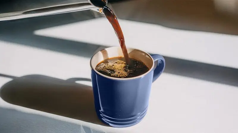 A person pouring coffee into a mug.