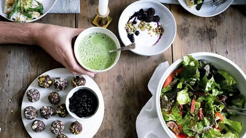 A person eating a meal with many plant-based foods.
