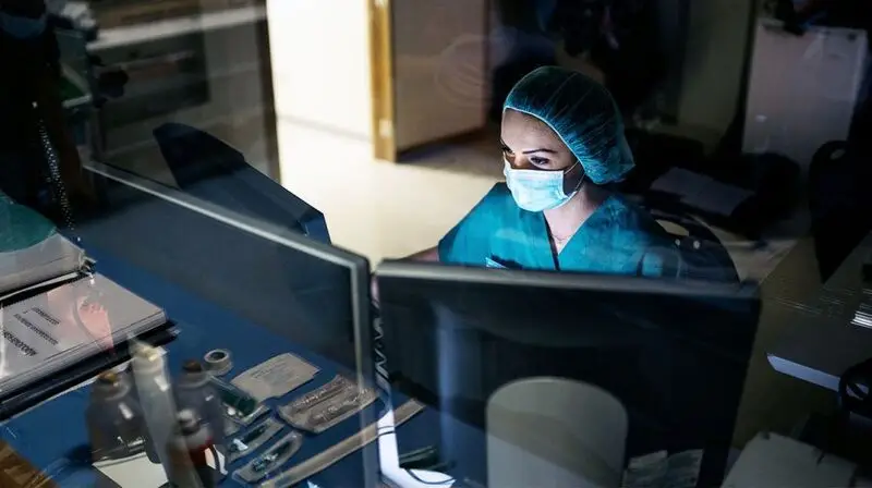 A healthcare professional looking at scan results on a monitor.