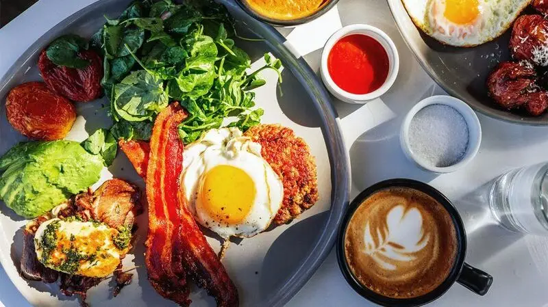 Keto breakfast with ground beef, avocado, bacon, halloumi cheese, tomato and spinach
