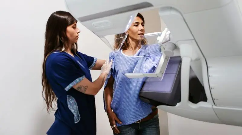 A person receiving a mammogram.