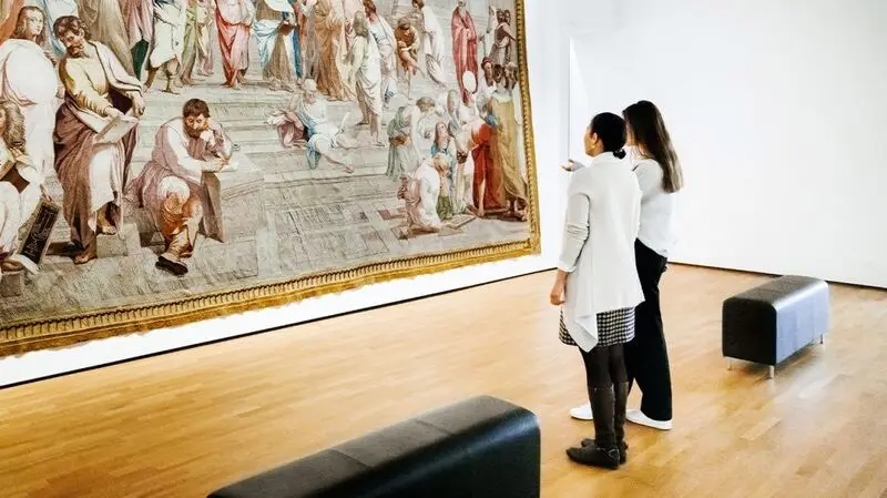 two people admiring a tapestry in an art gallery