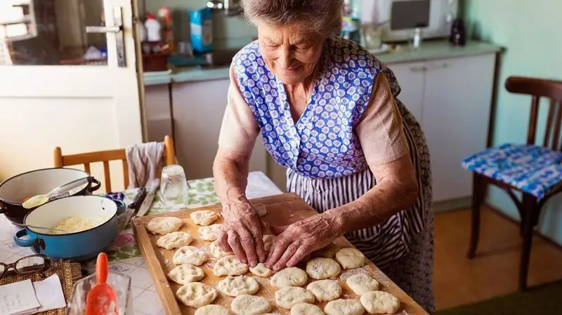 older white woman preparing a tray of cookies
