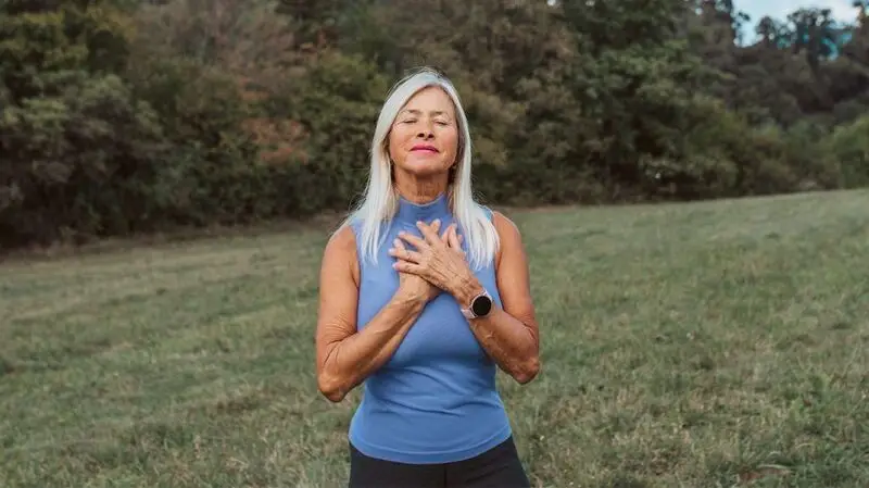 older white woman with long black hair in nature