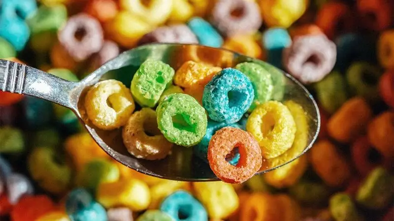 Colorful, loop shaped breakfast cereal on a spoon, a prime example of ultra processed foods