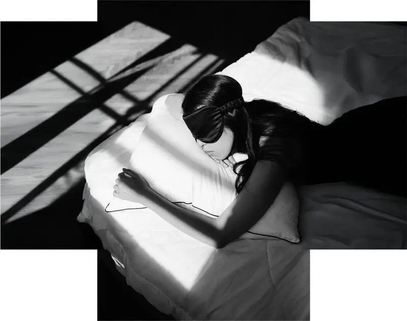 person asleep in bed wearing eye mask