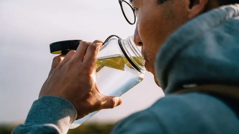 Closeup of a person drinking water.