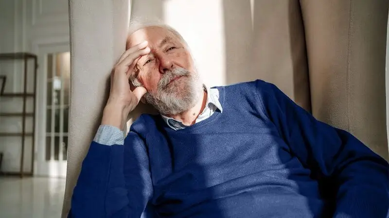 A person has their hand on their head and is leaning to the side.